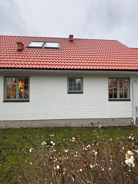 Vit villa med rött tegeltak och nya zinkgröna Retrofönster med spröjs