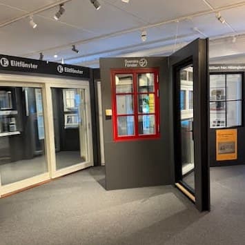 Fönster från Elitfönster och Svenska Fönster i showroomet, bland annat ett rött spröjsat fönster